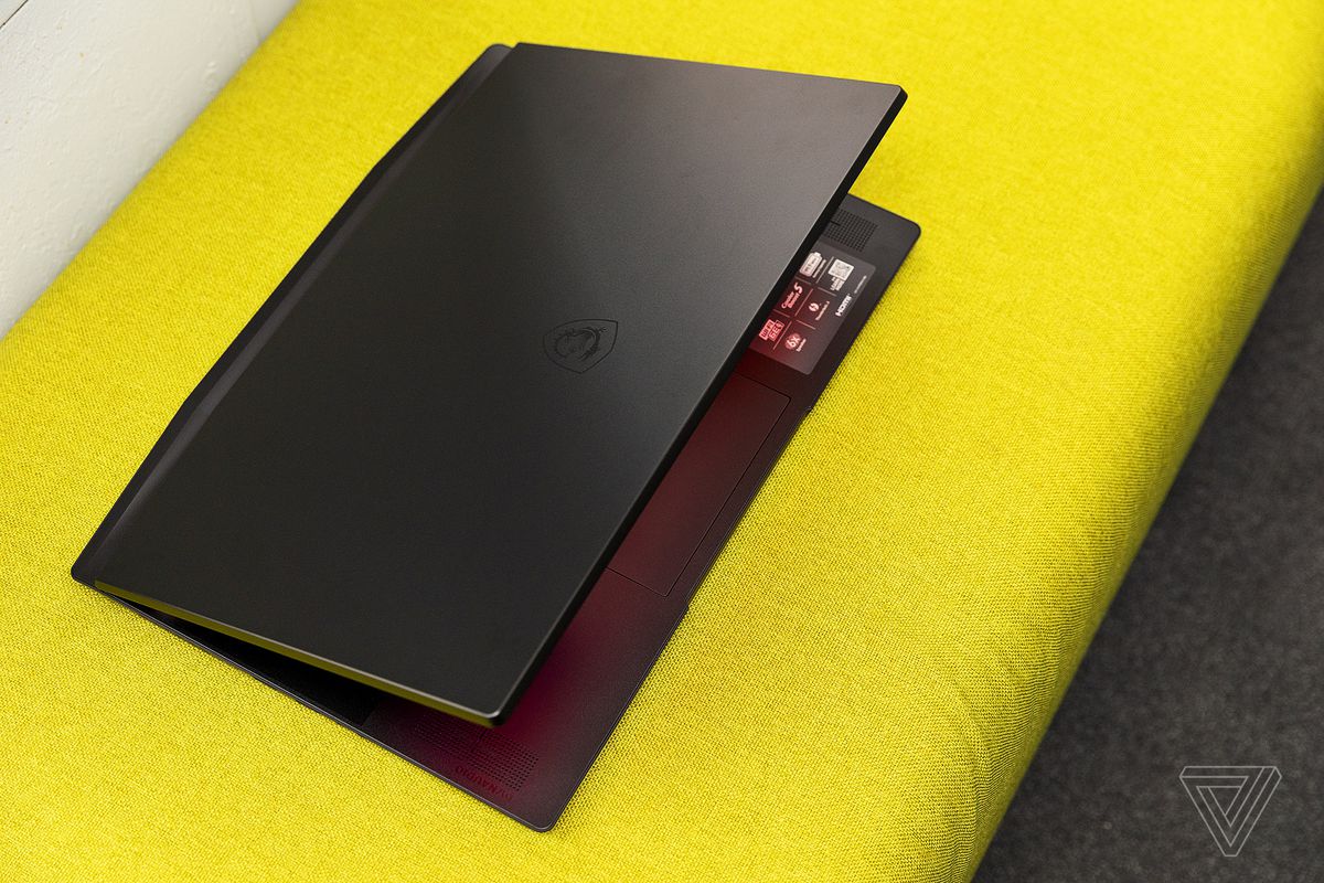 The MSI GS77 Stealth is seen from the top half open on a green fabric seat.