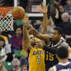 Utah Jazz power forward Derrick Favors (15) passes the ball back as Los Angeles Lakers small forward Xavier Henry (7) defends during a game at EnergySolutions Arena on Friday, Dec. 27, 2013.