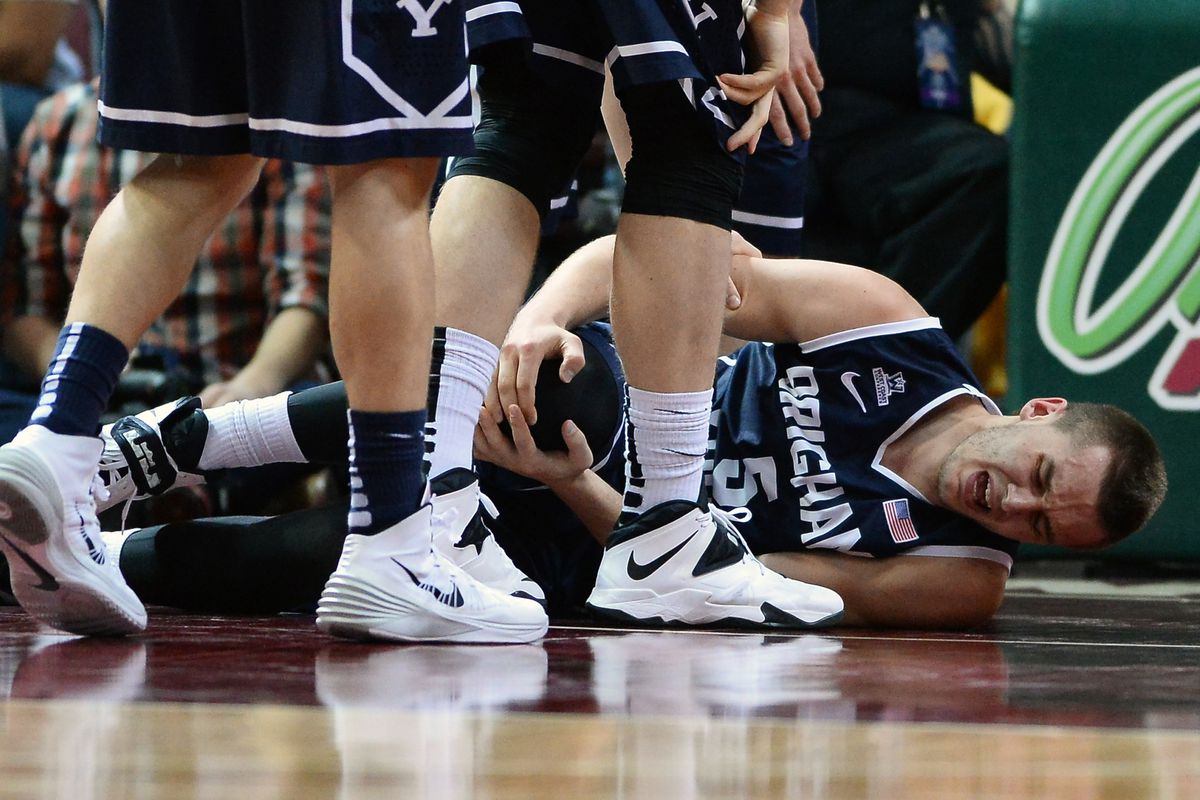 Kyle Collinsworth holds his knee immediately after injuring it in the WCC Tournament Final.