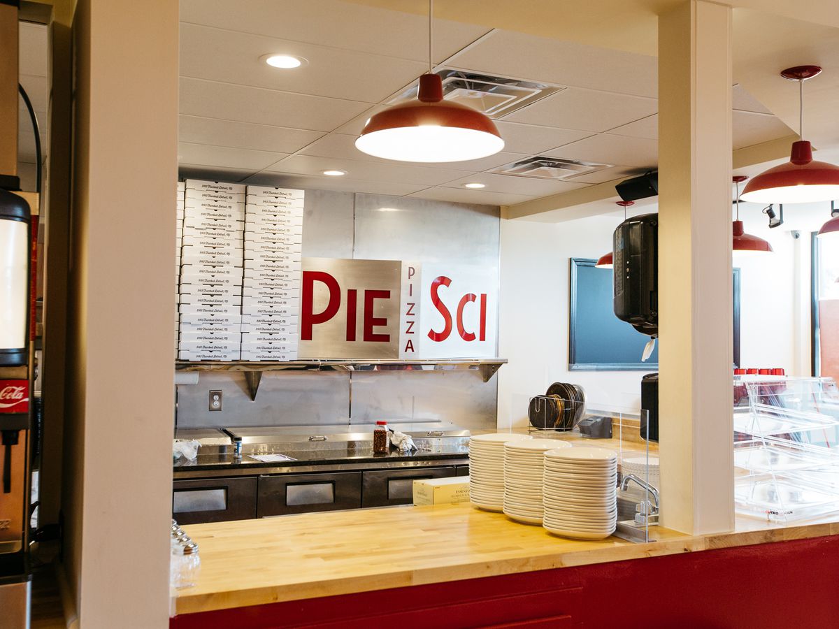 The red sign behind the wood counter at Pie-Sci in Woodbridge.