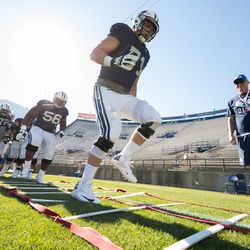 BYU offensive linemen, including Austin Hoyt (71) and Tejan Koroma (56), go through drills prior to the team's scrimmage at LaVell Edwards Stadium on Saturday, Aug. 13, 2016.