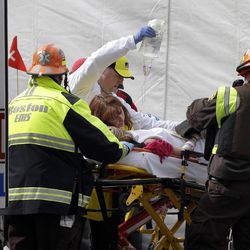 An injured person is loaded into an ambulance in the aftermath of two blasts which exploded near the finish line of the Boston Marathon in Boston Monday, April 15, 2013. Two bombs exploded near the finish line of the Boston Marathon on Monday, killing two people, injuring 23 others and sending authorities rushing to aid wounded spectators. A senior U.S. intelligence official said two other explosive devices were found nearby.