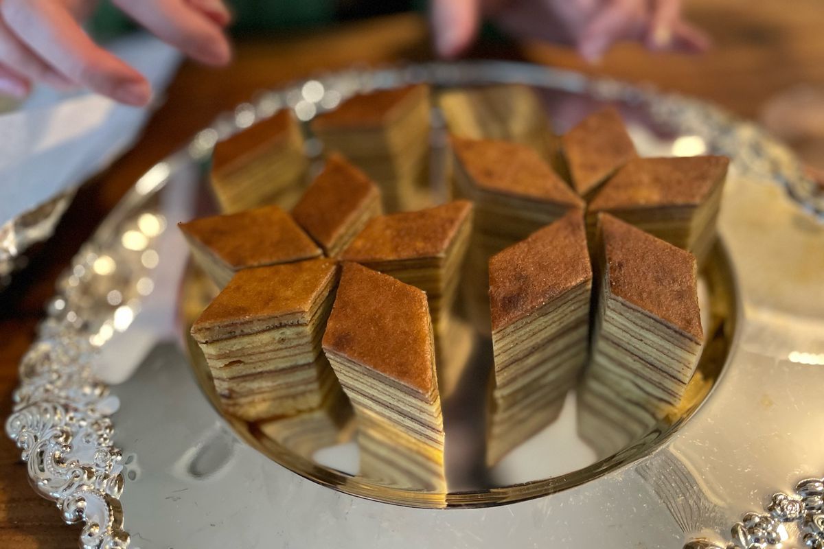 A silver tray of angularly-cut layer cake desserts.