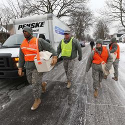 Michigan National Guard Staff Sgt. James Green hands out a water test kit to be distributed to residents, Thursday, Jan. 21, 2016 in Flint, Mich. The National Guard, state employees, local authorities and volunteers have been distributing lead tests, filters and bottled water during  the city's drinking water crisis.  (AP Photo/Paul Sancya)