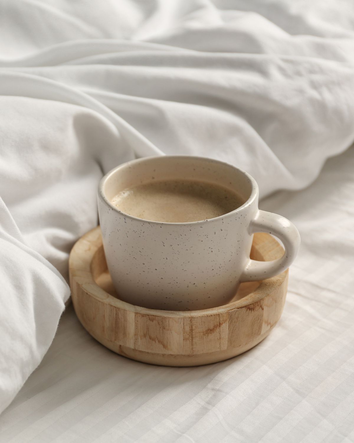 A cup of coffee in bed. 