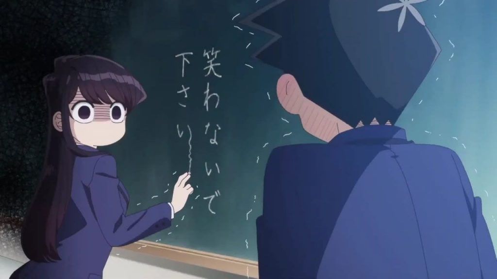 Shoko Komi nervously scribbling on a chalkboard as her crush Hitohito Tadano talks to her.
