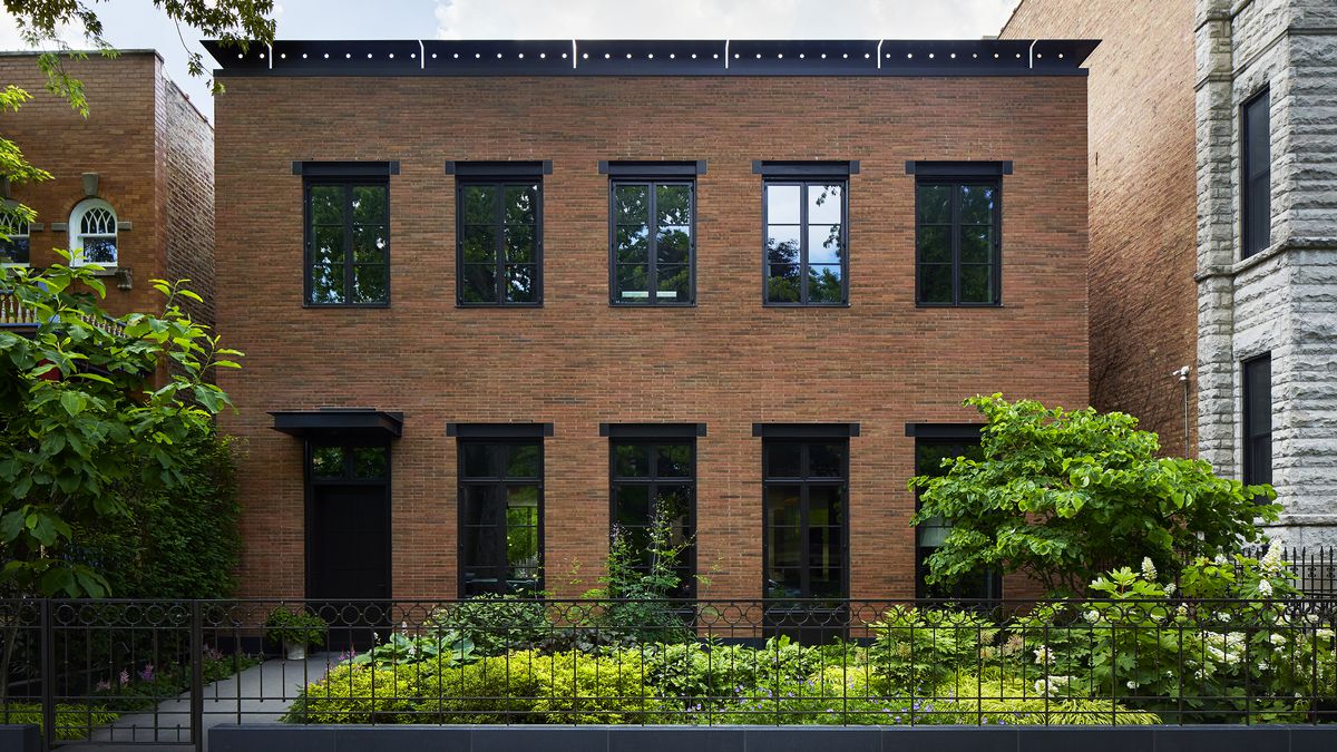 Like many buildings on this street, this one is made of red brick. A black metal cornice crafted with a series of circles and slices gives it away as a modern building.