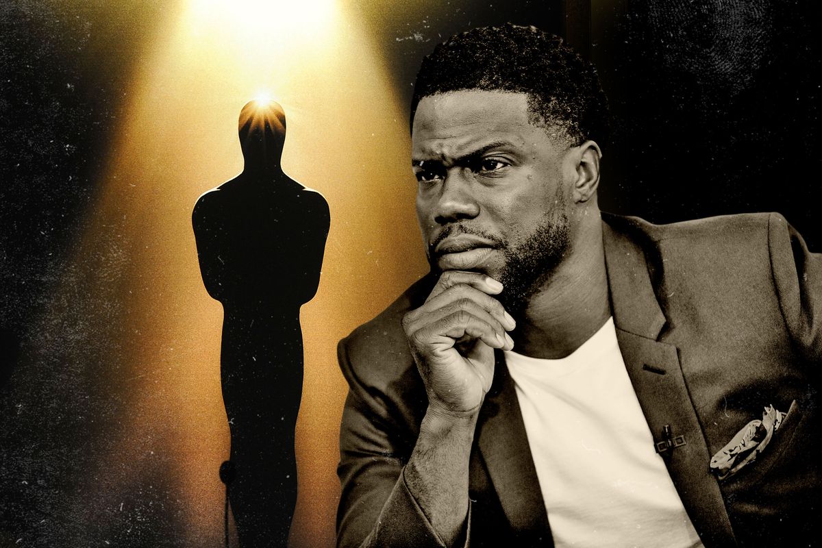 Kevin Hart with his hand on his chin in front of an Oscar statuette