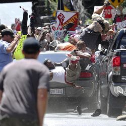 People fly into the air as a vehicle drives into a group of protesters demonstrating against a white nationalist rally in Charlottesville, Va., Saturday, Aug. 12, 2017. The nationalists were holding the rally to protest plans by the city of Charlottesville to remove a statue of Confederate Gen. Robert E. Lee. There were several hundred protesters marching in a long line when the car drove into a group of them. 