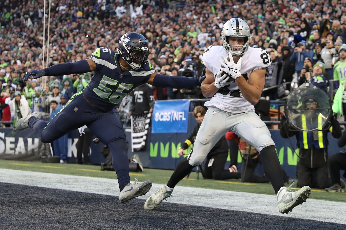 Foster Moreau #87 of the Las Vegas Raiders makes a catch for a touchdown past Jordyn Brooks #56 of the Seattle Seahawks in the fourth quarter at Lumen Field on November 27, 2022 in Seattle, Washington.