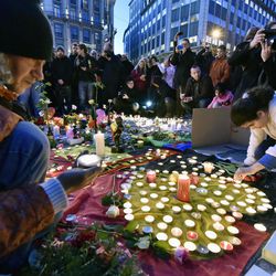 People bring flowers and candles to mourn for the victims at Place de la Bourse in the center of Brussels, Tuesday, March 22, 2016. Bombs exploded at the Brussels airport and one of the city's metro stations Tuesday, killing and wounding scores of people, as a European capital was again locked down amid heightened security threats. 