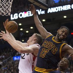 Toronto Raptors center Jakob Poeltl, left, reaches for the ball next to Cleveland Cavaliers center Tristan Thompson during the second half of an NBA basketball game in Toronto on Friday, Oct. 28, 2016. (Chris Young/The Canadian Press via AP)