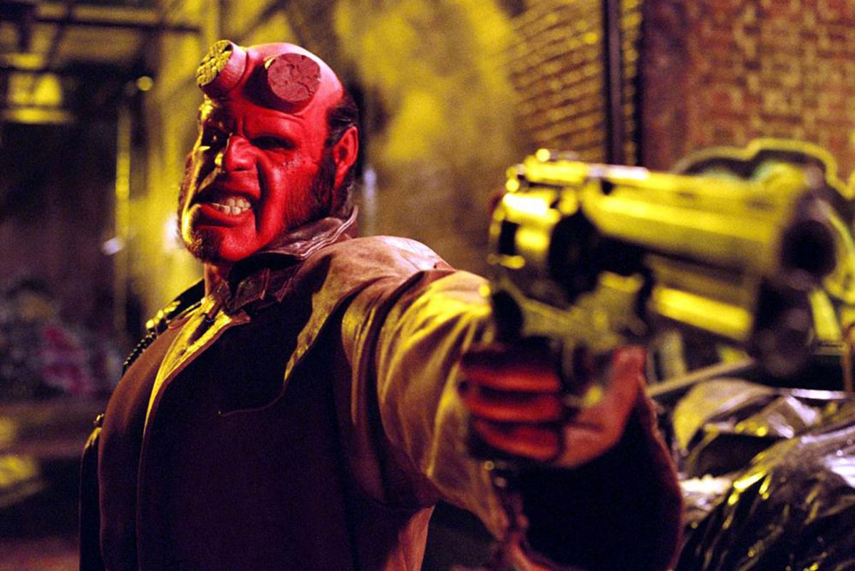 Ron Perlman, vestido de rojo, como Hellboy.