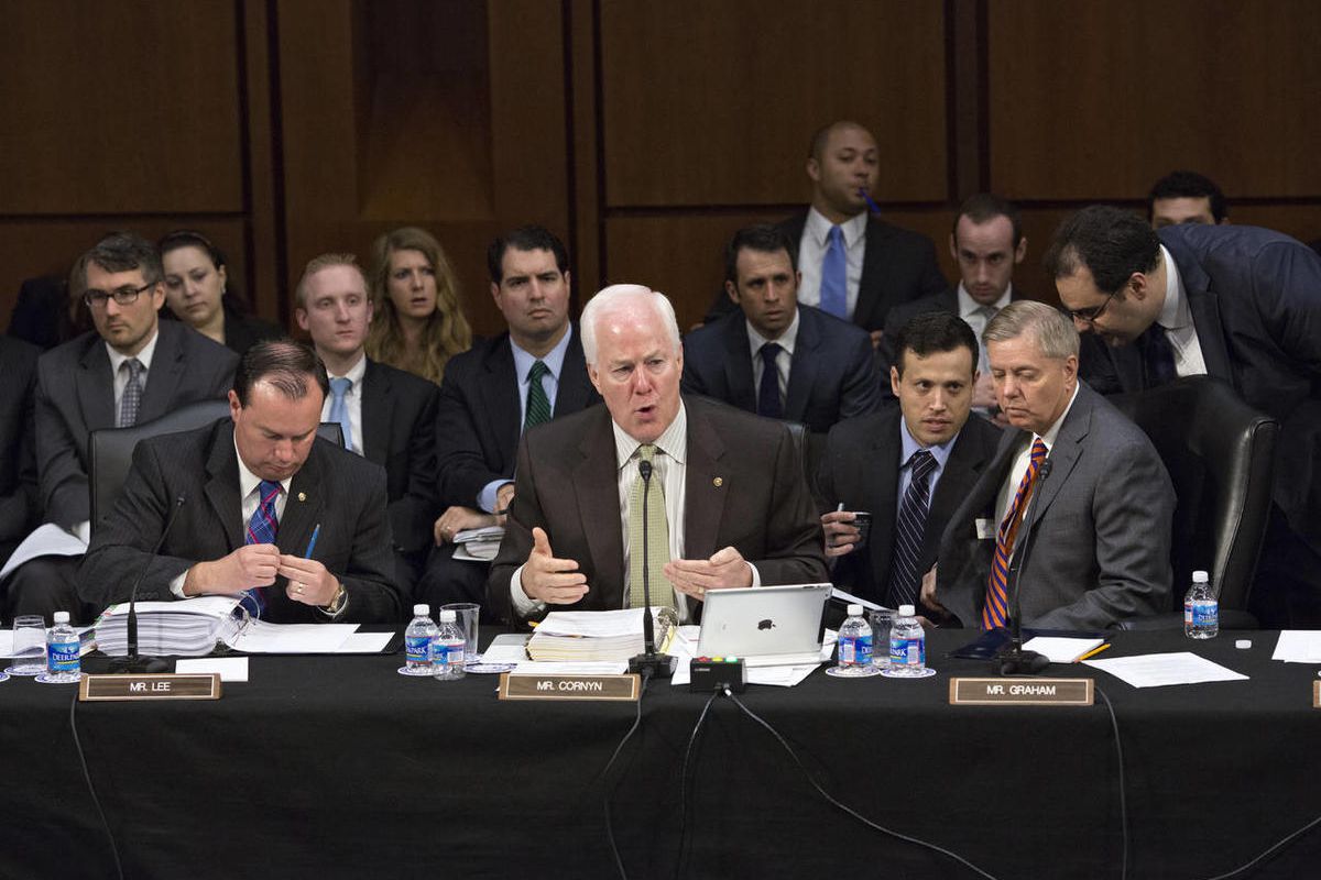 In this May 9, 2013, file photo Senate Judiciary Committee members, Sen. John Cornyn, R-Texas, center, Sen. Mike Lee, R-Utah, left, and Sen. Lindsey Graham, R-S.C., seated right, discuss proposed changes to immigration reform legislation during the commit