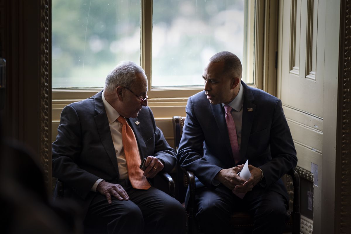 Jeffries, his black hair cut nearly to his scalp and clean shaven, sits next to Schumer in chairs by a window. The men both wear dark blue suits and white shirts, Schumer with a salmon colored tie, Jeffries with a pink one. Schumer’s glasses dangle from the tip of his nose. 