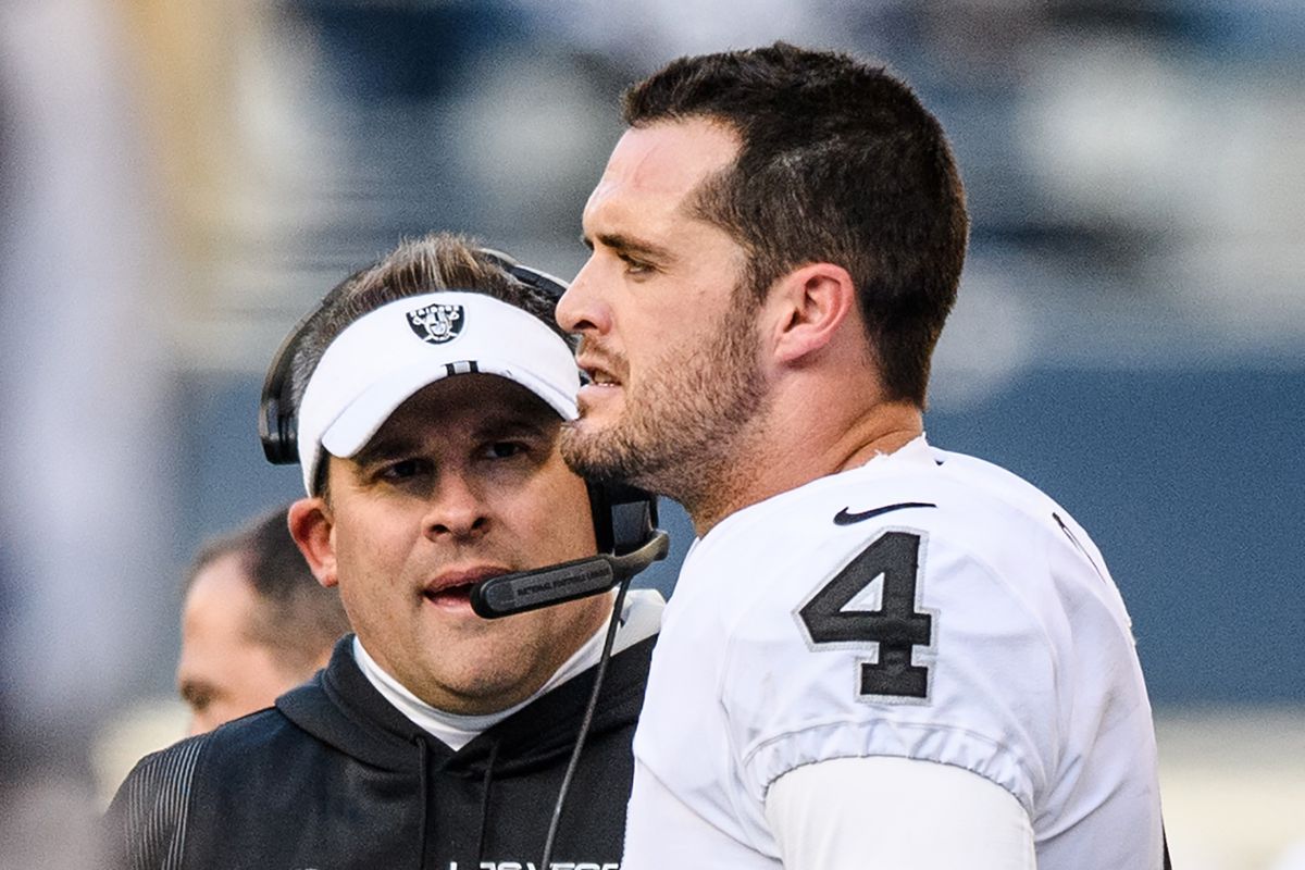 Derek Carr #4 of the Las Vegas Raiders chats with head coach Josh McDaniels during the first half of the game against the Seattle Seahawks at Lumen Field on November 27, 2022 in Seattle, Washington.