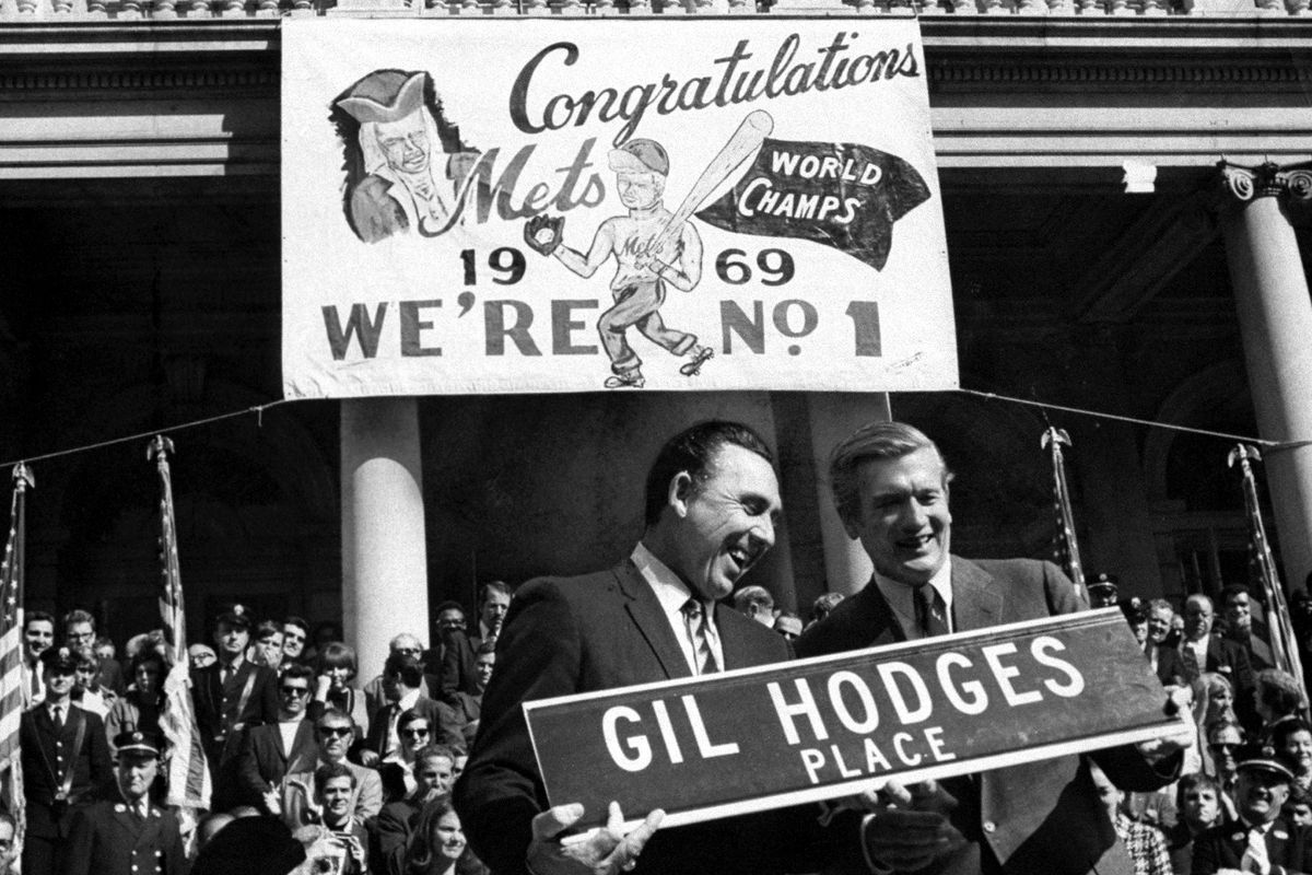 Gil Hodges (left) and Mayor John Lindsay hold up a street si