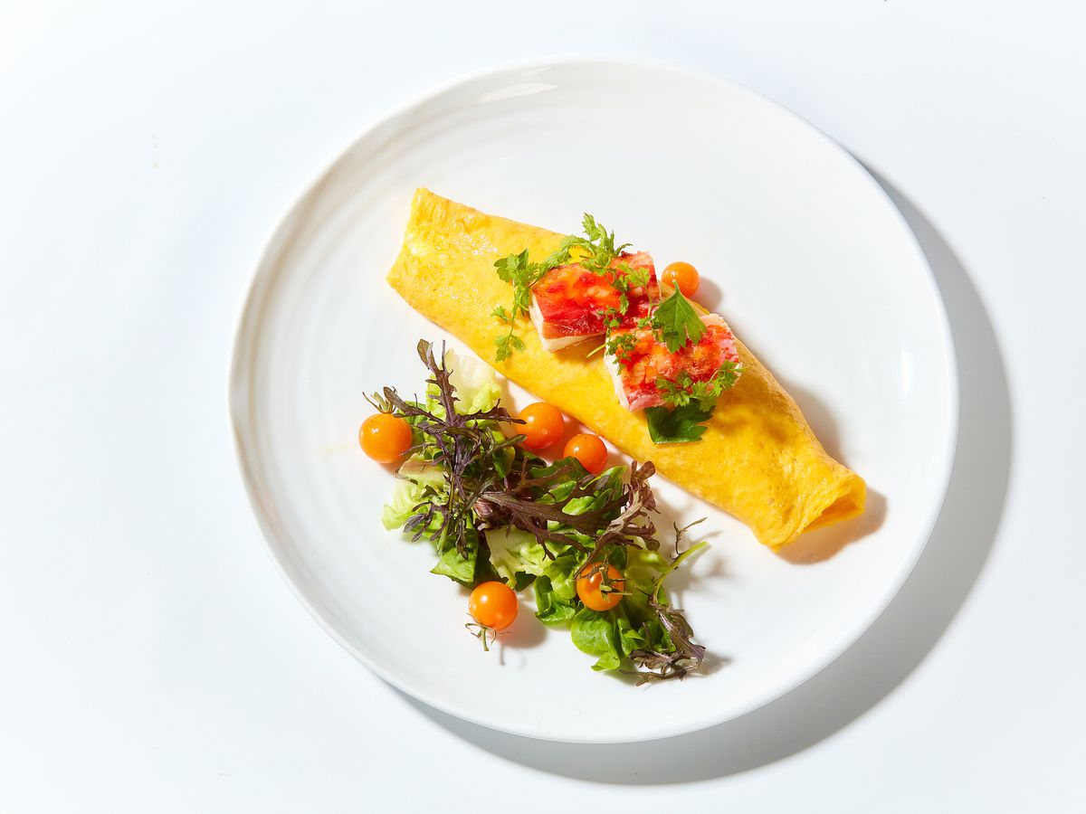 An omelet with a salad on a white plate
