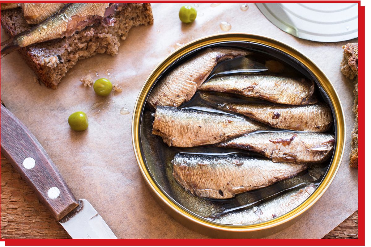An open can of sardines with the filets still in their oil.