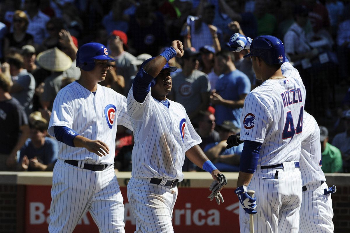 Bryan LaHair and Luis Valbuena of the Chicago Cubs are greeted by Anthony Rizzo after scoring against the Cincinnati Reds at Wrigley Field in Chicago, Illinois. (Photo by David Banks/Getty Images) 