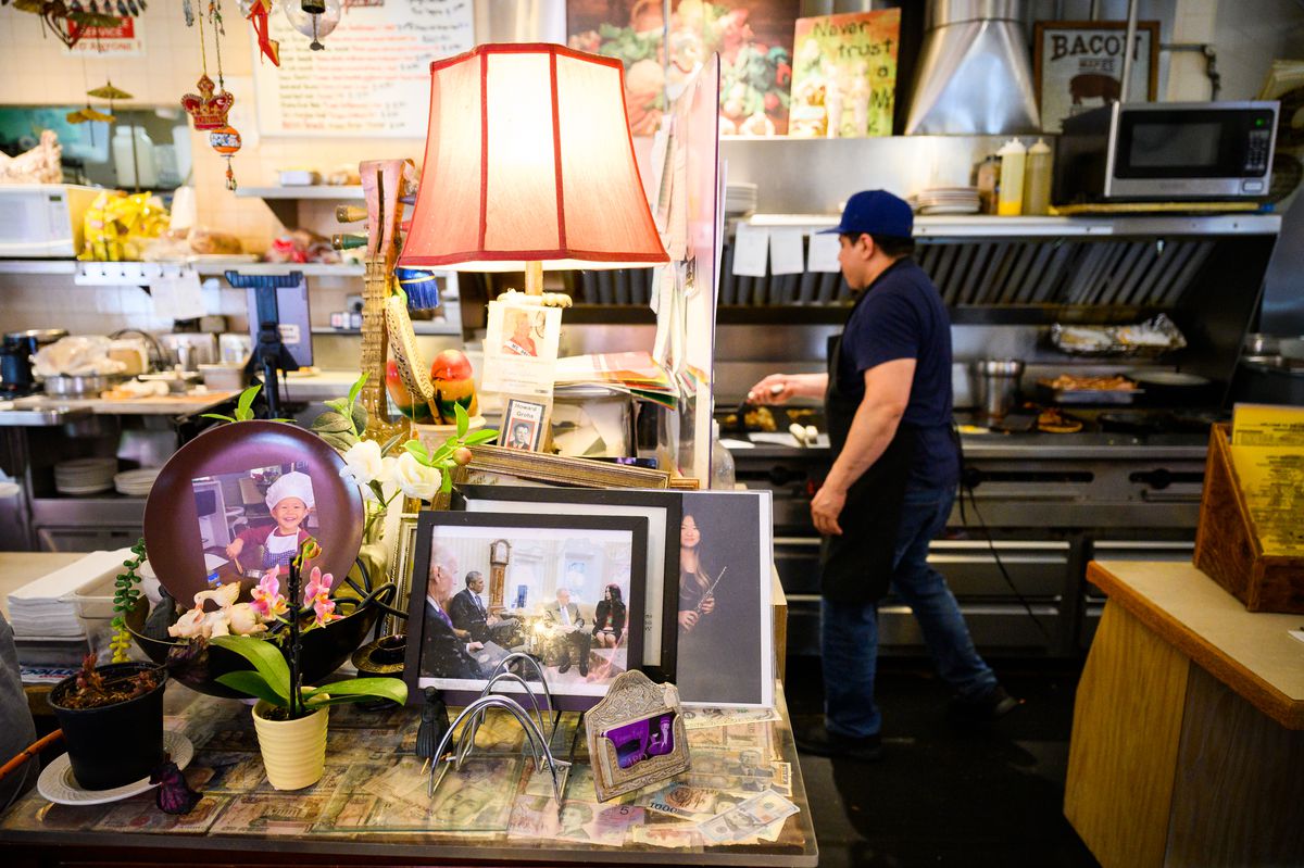 A counter crowded with photos inside Cameo Cafe.