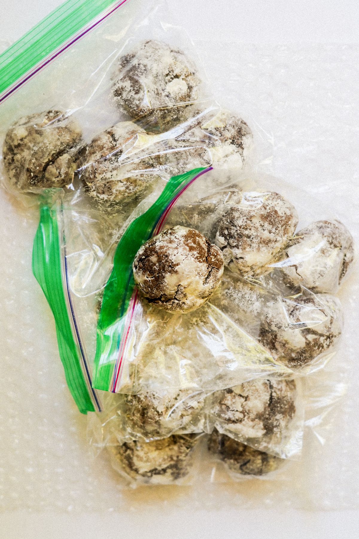 Chocolate crinkle cookies placed in plastic ziptop bags.