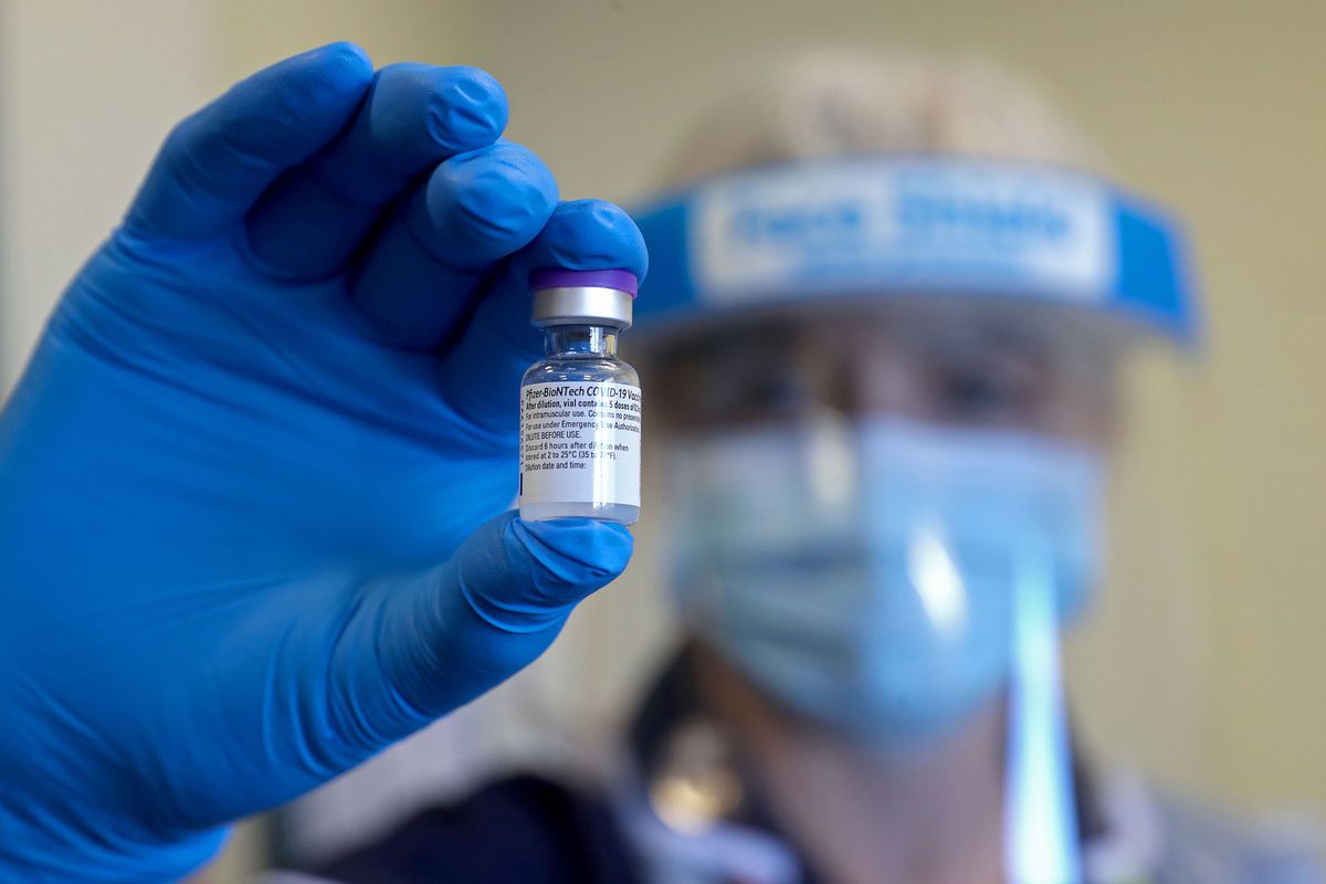 A health care worker in the UK holds up a vial of the Pfizer-BioNTech Covid-19 vaccine on December 17, 2020.