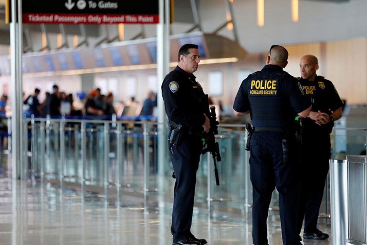 A San Diego Harbor police officer chats with Homeland Security officers while on patrol at Lindbergh Field airport in San Diego, California, on July 1, 2016.