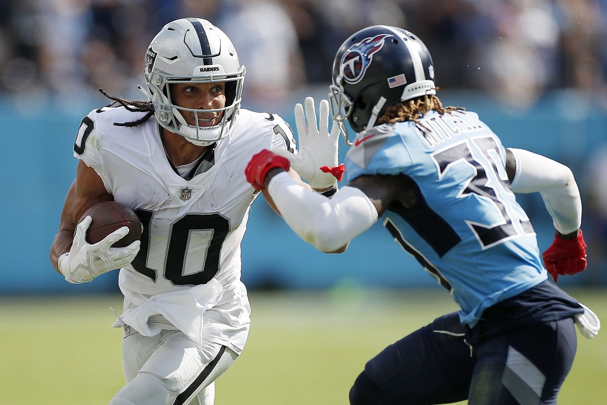 Mack Hollins #10 of the Las Vegas Raiders runs with the ball against Terrance Mitchell #39 of the Tennessee Titans during the fourth quarter at Nissan Stadium on September 25, 2022 in Nashville, Tennessee.
