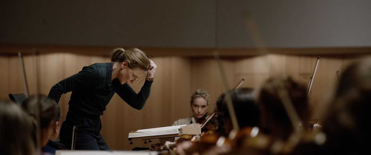 Lydia Tár (Cate Blanchett) makes a powerful downward gesture while conducting the Berlin Philharmonic in Todd Field's Tár