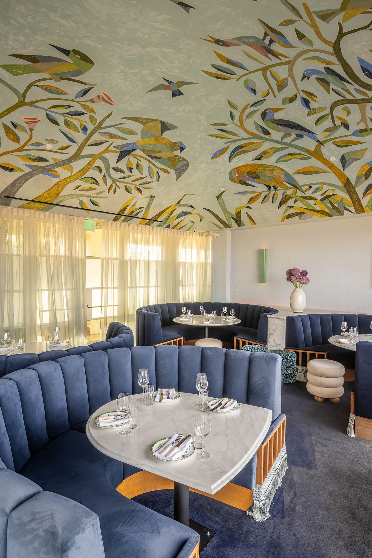 Blue plush booths, marble tables, and a ceiling fresco in the dining room at Dante Beverly Hills.