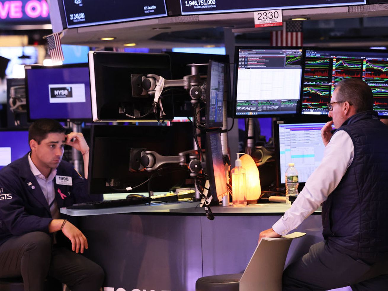 Two men on the New York Stock Exchange floor working.