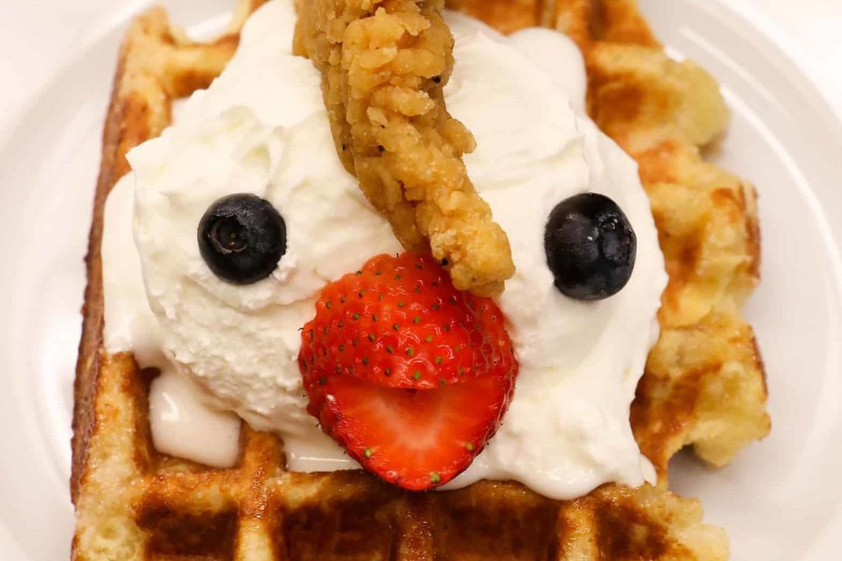 The sweet and savory “Waffle Monster” prepared with chicken tenders, a strawberry beak and a  Belgium waffle and whipped cream.
