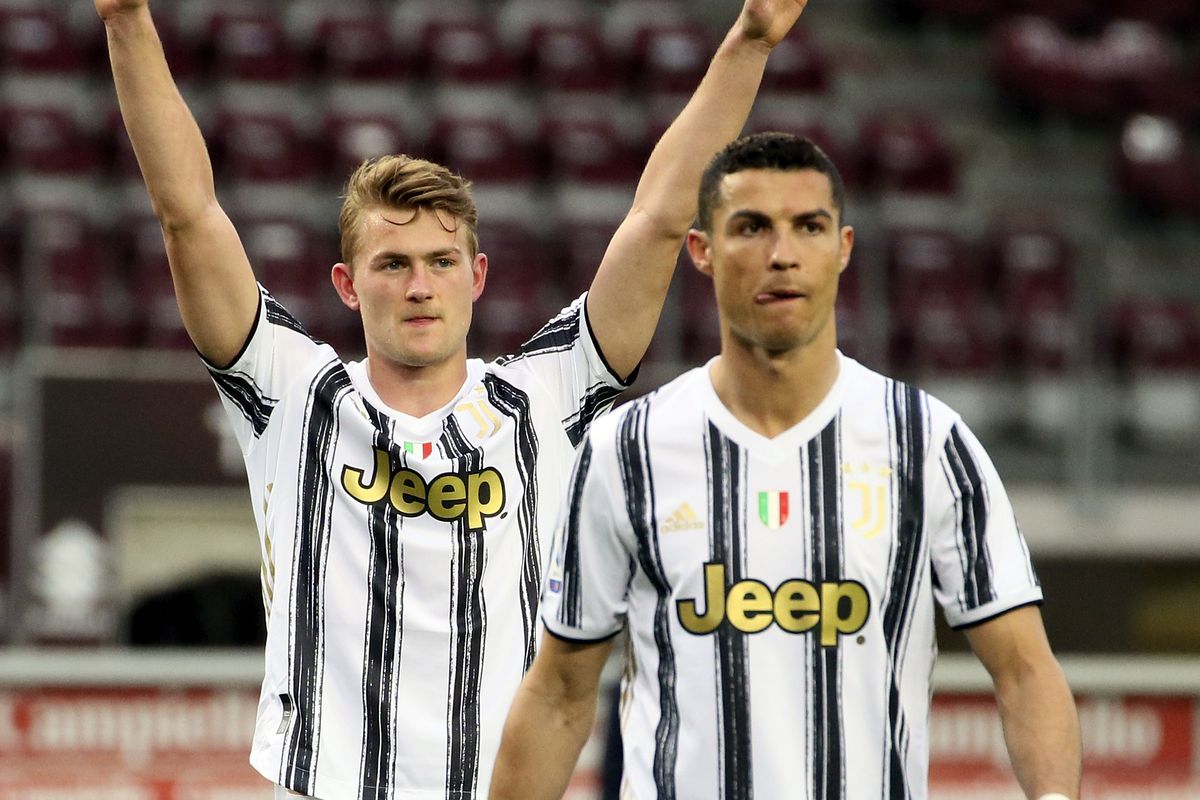 Matthijs de Ligt lifts his arms in celebration as he stands next to Cristiano Ronaldo during a Serie A match in 2021
