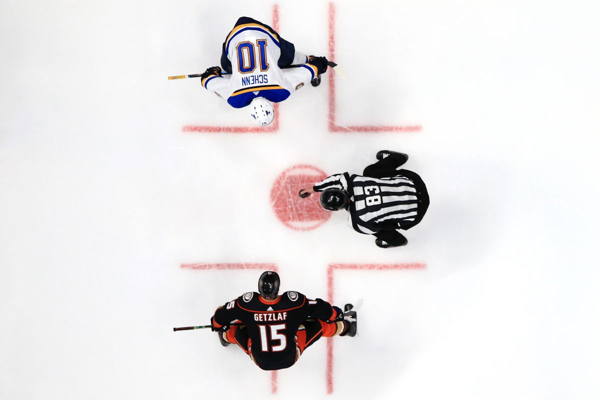 Linesman Matt MacPherson drops the puck on a face off for Brayden Schenn of the St. Louis Blues and Ryan Getzlaf of the Anaheim Ducks during the second period of a game at Honda Center on March 11, 2020 in Anaheim, California.