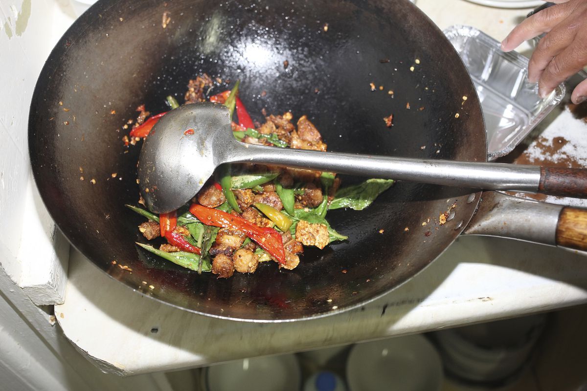 Moo krob, twice-cooked pork with chilli and basil, in the wok at Singburi, one of the best and best-value restaurants in London