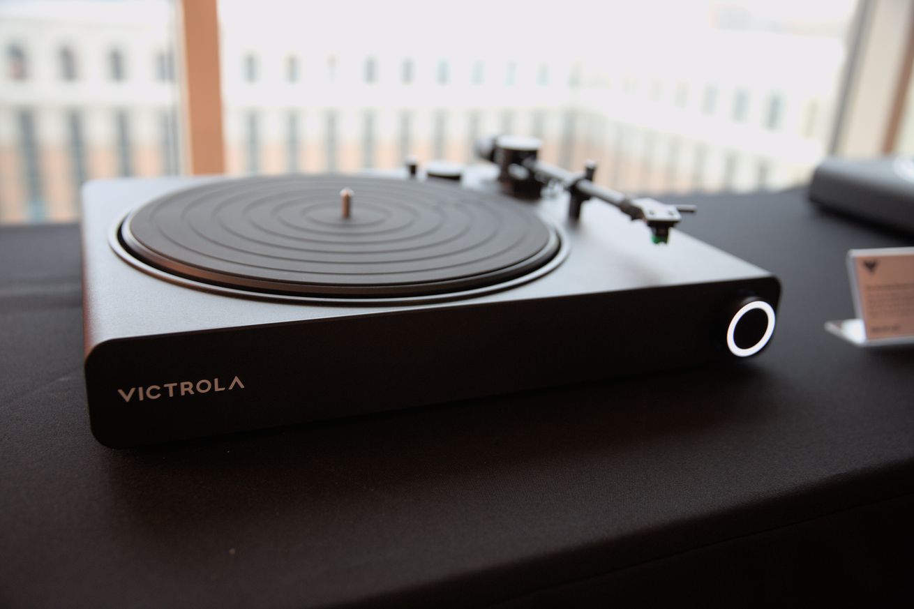 The Victrola Stream Onyx turntable sitting on a black desk.
