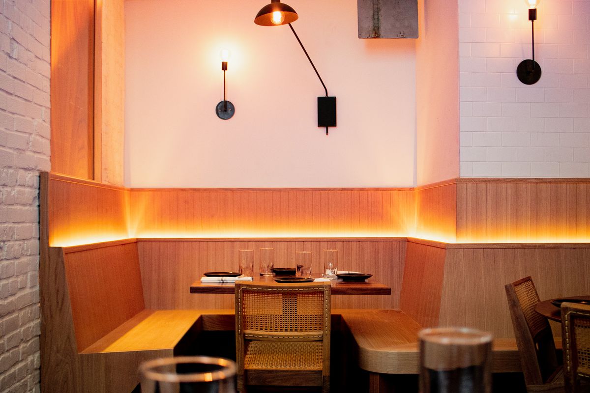 A back-lit wooden banquette runs along one side of the restaurant’s dining room.