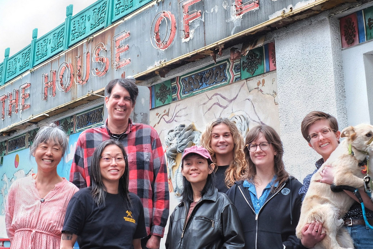 A group of people stand in front of the House of Louie space.