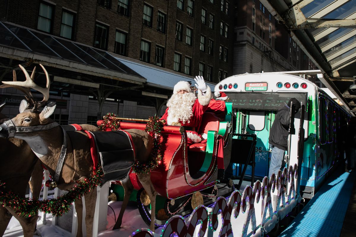 Santa Claus waves to people on the platform as he rides the Allstate Chicago Transit Authority Holiday Train around the Loop Monday afternoon, Dec. 20, 2021. 