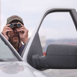 Doug Adams uses binoculars to look for his house from the parking lot of and LDS church in Fruitland on Wednesday, July 11, 2018. Adams' house was destroyed in the Dollar Ridge Fire.