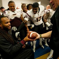 Coach Graham presents the game ball for the win over Cal to Angelo Richardson