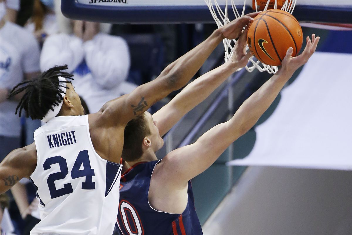 Brigham Young Cougars forward Seneca Knight (24) blocks the shot by Saint Mary’s Gaels center Mitchell Saxen (10) in Provo on Saturday, Jan. 8, 2022. BYU won 52-43.