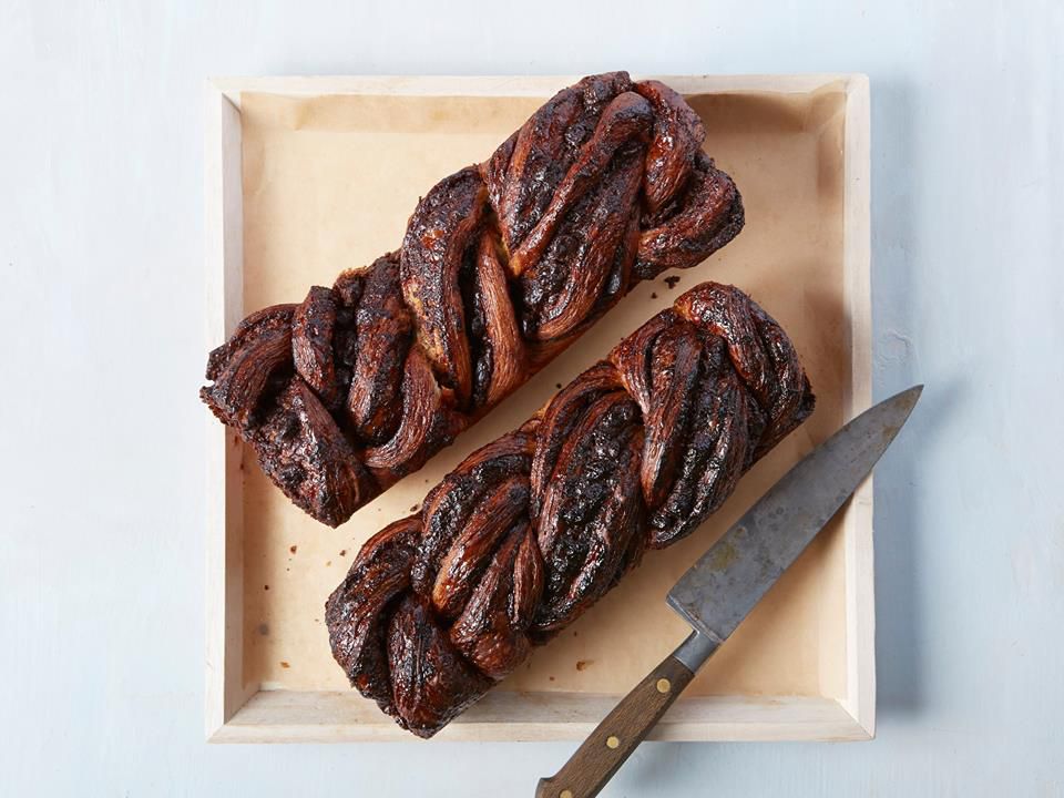 An overhead photo of two loaves of chocolate babka beside a cutting knife