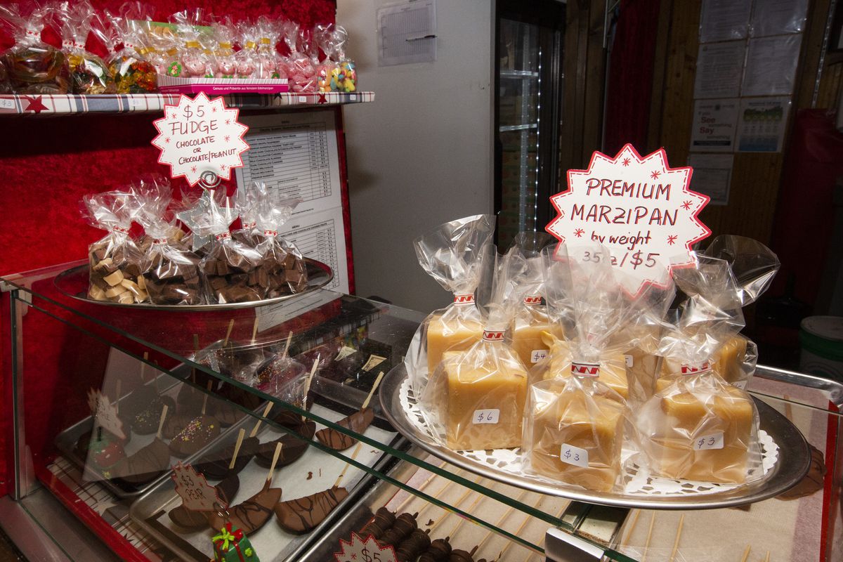 Two trays of fudge and marzipan sit on a glass display case.