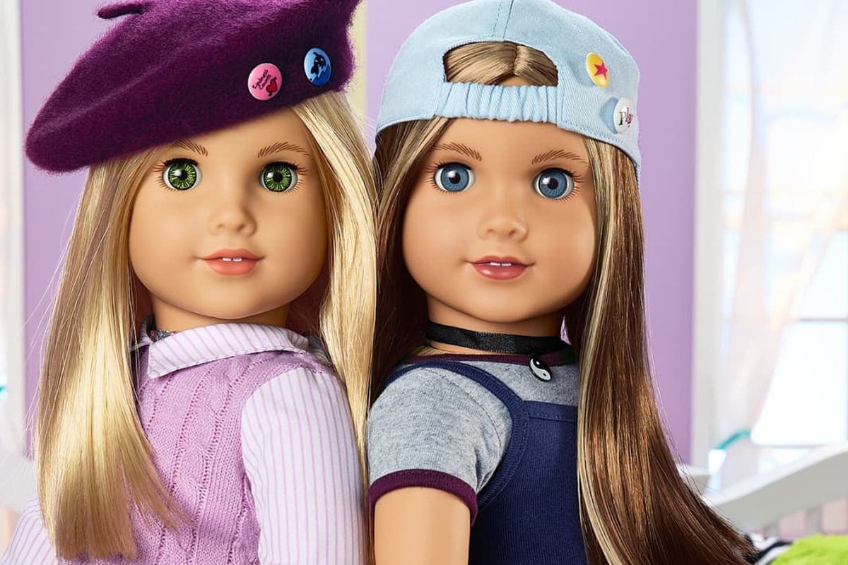 two dolls stand back to back; next to them are words that say Meet Isabel and Nicki, 1999