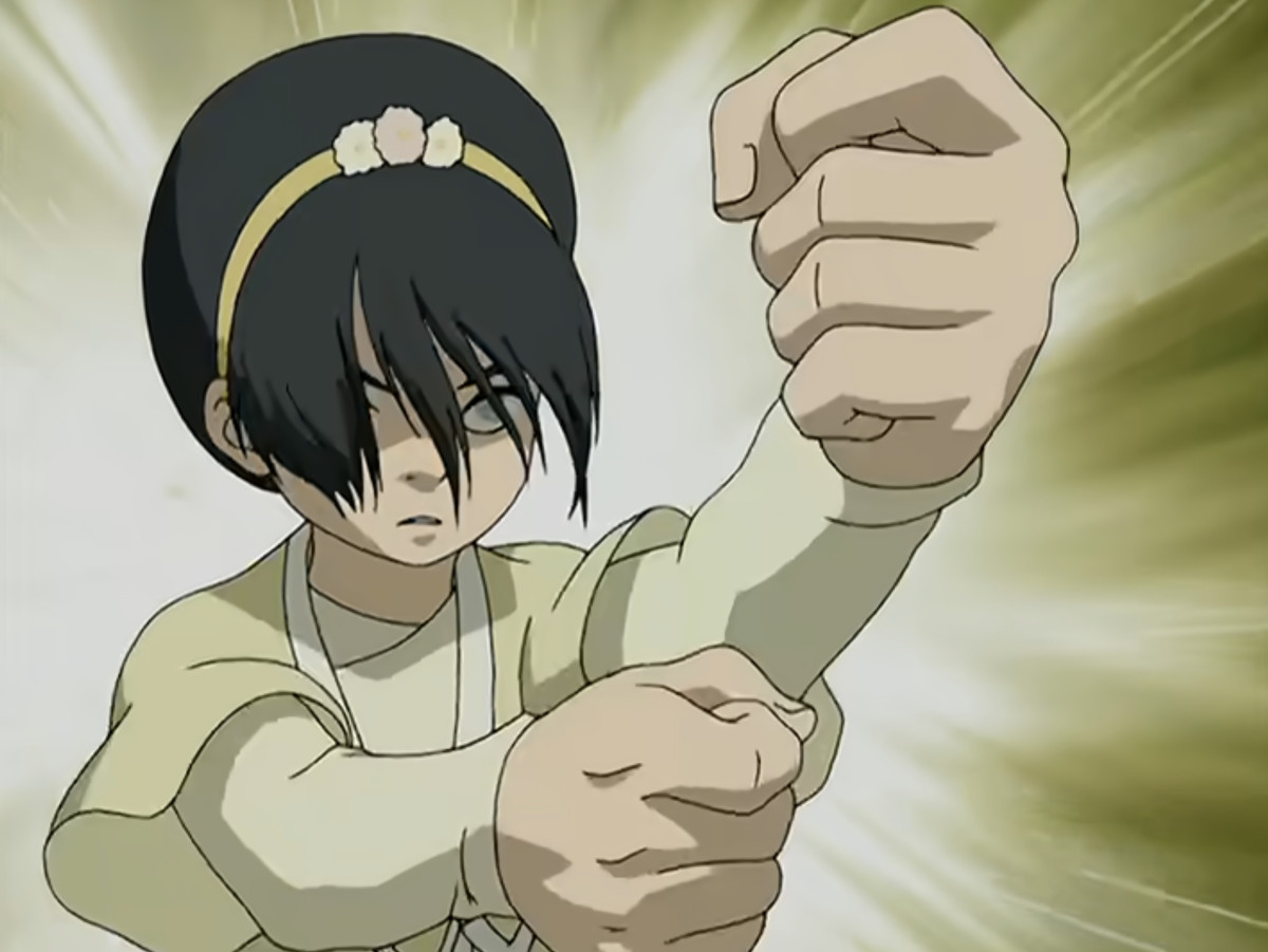 A still from the Avatar: The Last Airbender animated tv series where Toph takes a fighting stance while Earthbending. 