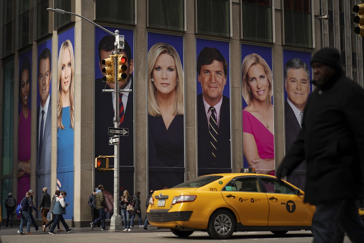 A cab passing by the News Corporation building, which bears advertisements of Fox News personalities (from left) Martha MacCallum, Tucker Carlson, Laura Ingraham, and Sean Hannity, on March 13, 2019 in New York City.