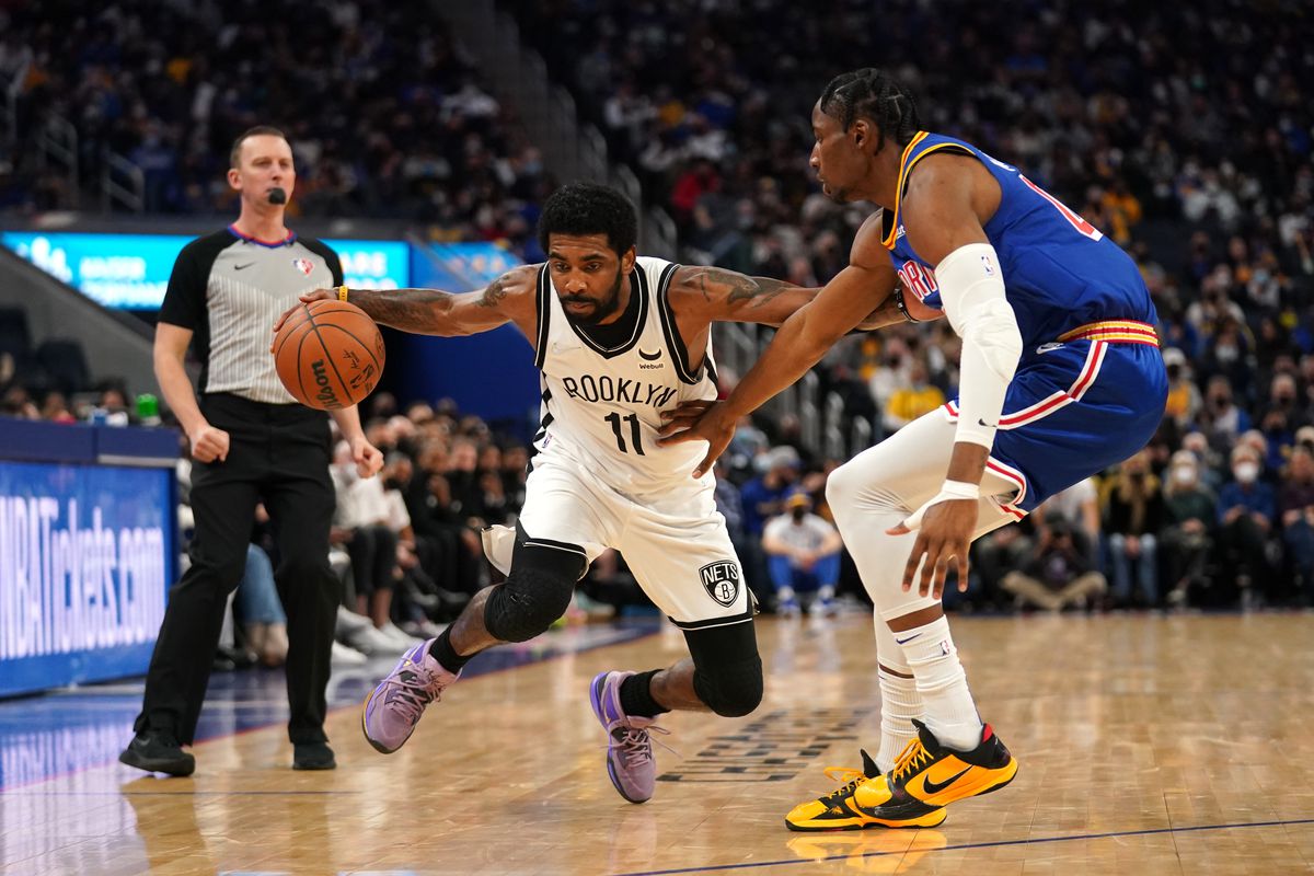 Brooklyn Nets guard Kyrie Irving (11) dribbles against Golden State Warriors forward Jonathan Kuminga (00) in the third quarter at the Chase Center.