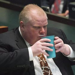 FILE - In this Nov. 14, 2013 file photo, Toronto Mayor Rob Ford displays a milk moustache as he takes part in voting with city council members in Toronto. Ford, whose career crashed in a drug-driven, obscenity-laced debacle, died Tuesday, March 22, 2016 after fighting cancer, his family says. He was 46.